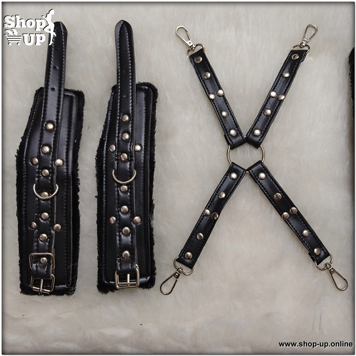 كلبشات جلدية سوداء مبطنة بالفرو مع أشرطة توصيل متقاطعة مزينة بمسامير وحلقات معدنية فضية.